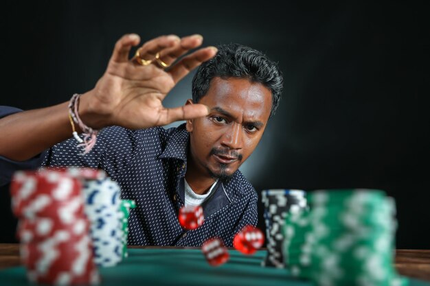 confident mature man rolling dice craps table against black background 1048944 13117836